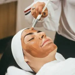Application d'un masque sur le visage, étape clé d'un massage lymphatique visage relaxant.