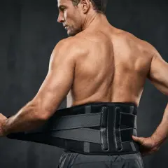 Un homme ajuste une ceinture de soutien pour les spinaux lombaires dans une salle de sport.