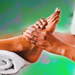 Mains expertes prodiguant un massage pied relaxant, avec une serviette blanche enroulée à proximité.