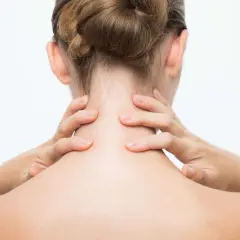 Mains massant une nuque raide, signe de stress.
