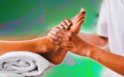 Mains expertes prodiguant un massage pied relaxant, avec une serviette blanche enroulée à proximité.