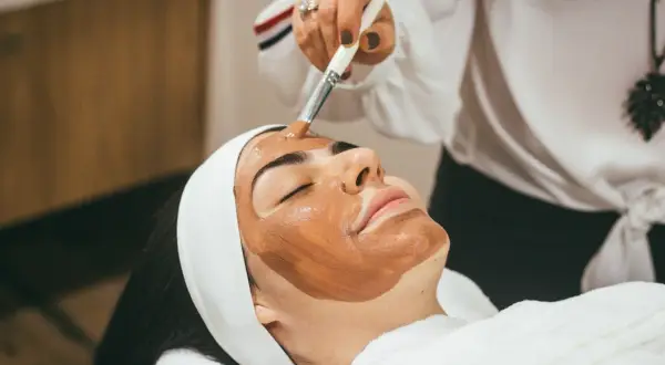 Application d'un masque sur le visage, étape clé d'un massage lymphatique visage relaxant.
