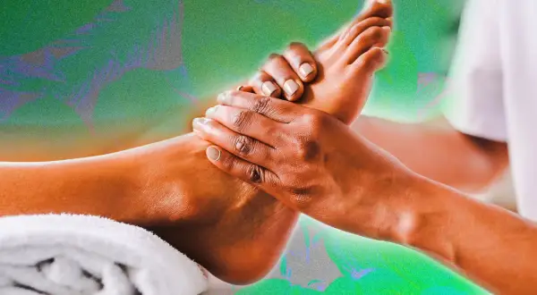 Mains massant un pied, évoquant la réflexologie plantaire colonne vertébrale pour un bien-être total.