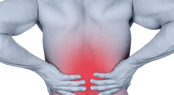 Douleur dans le bas du dos, zone rouge sur le muscle longissimus. Homme tenant ses reins.