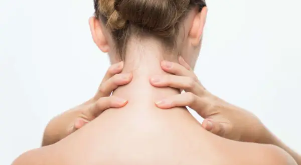 Mains massant une nuque raide, signe de stress.