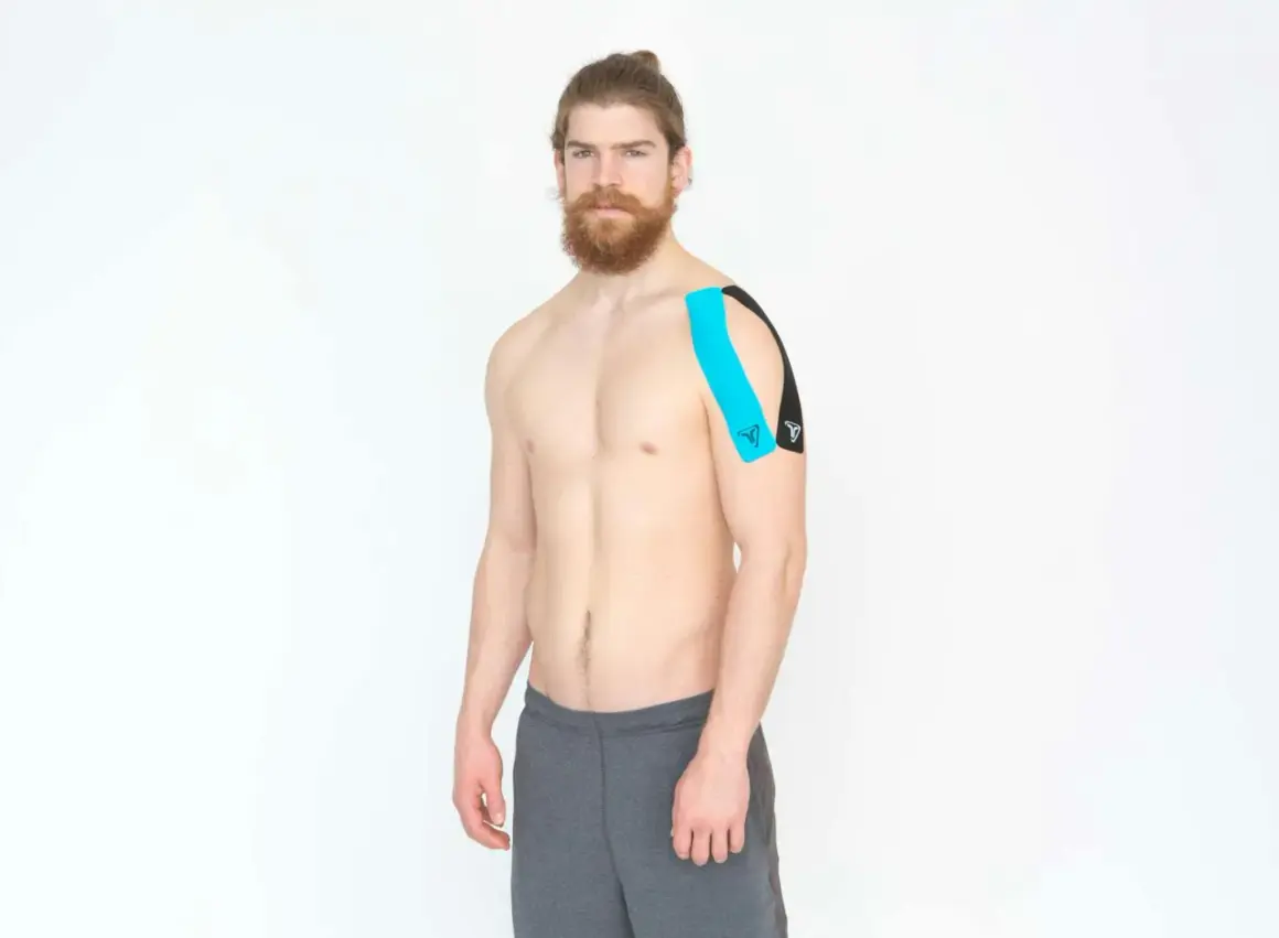 Homme avec un taping bleu et noir sur l'épaule, pour le soutien de la coiffe rotateur.