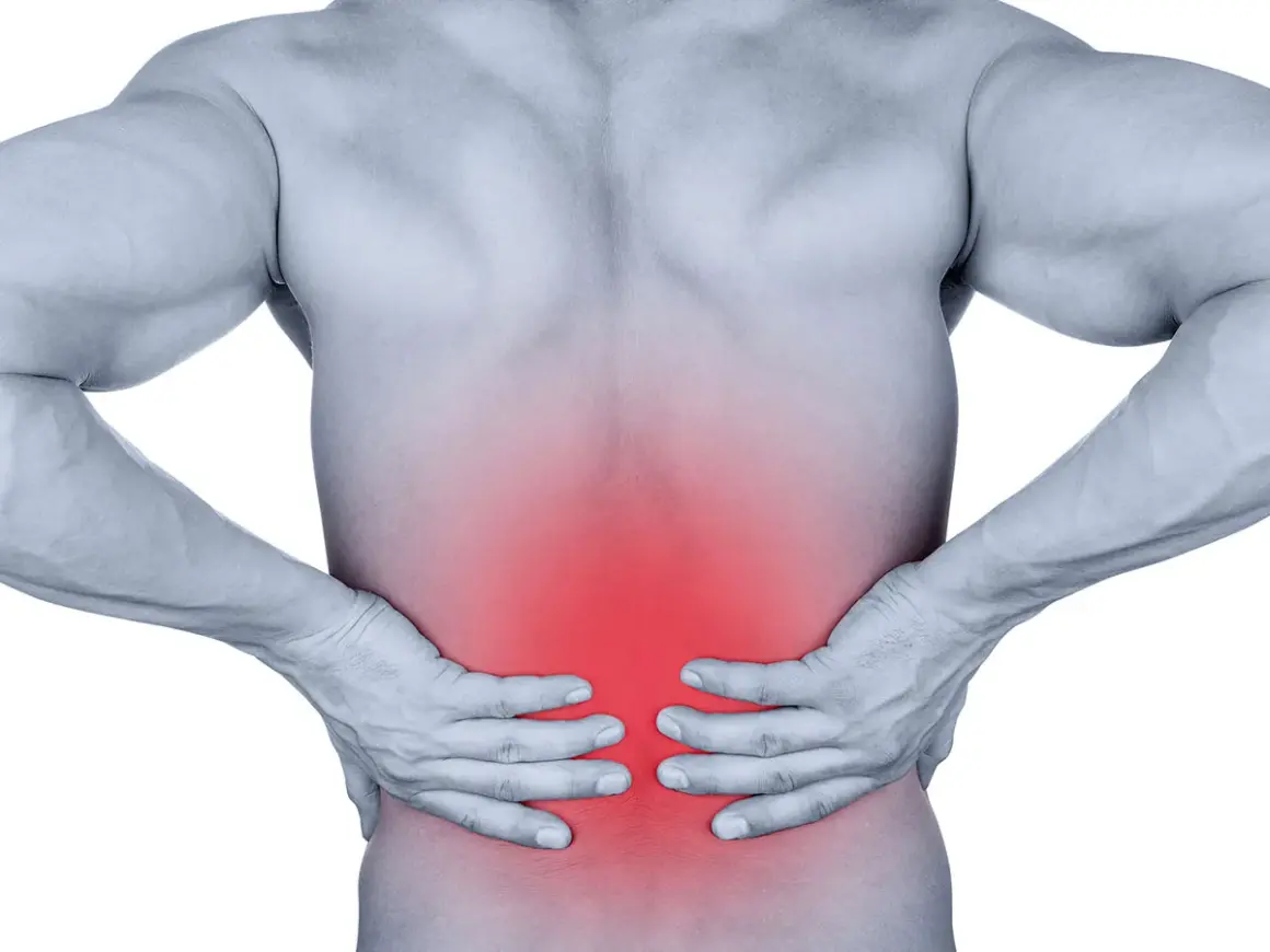 Douleur dans le bas du dos, zone rouge sur le muscle longissimus. Homme tenant ses reins.