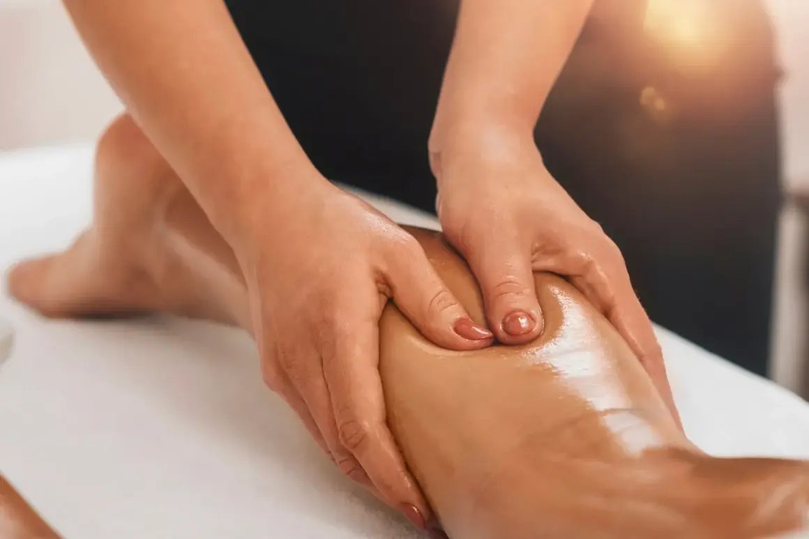 Mains massant un mollet huilé, profitant des bienfaits relaxants et décontractants pour soulager les tensions musculaires.