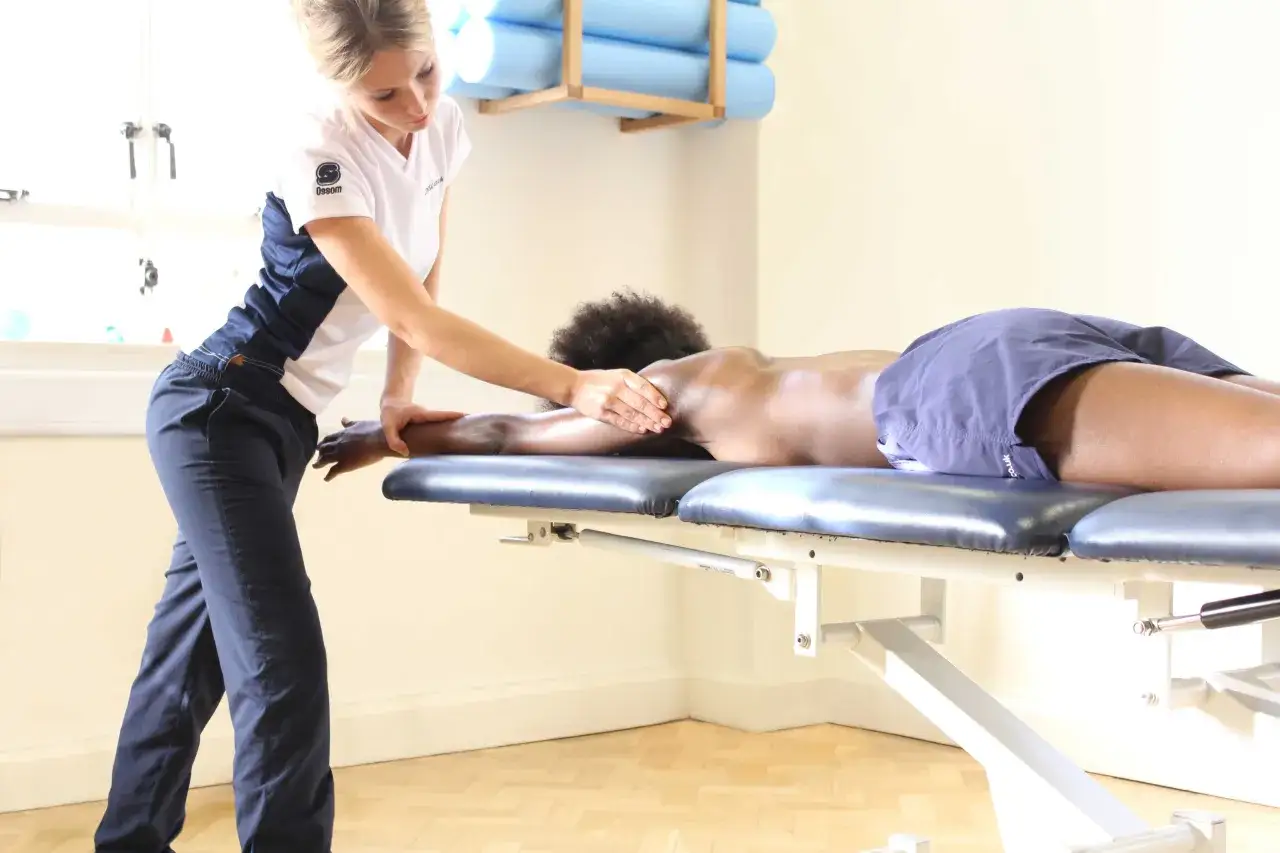 Th&eacute;rapeute effectuant un massage pour am&eacute;liorer la circulation sanguine, soulageant les tensions musculaires sur une table de massage.