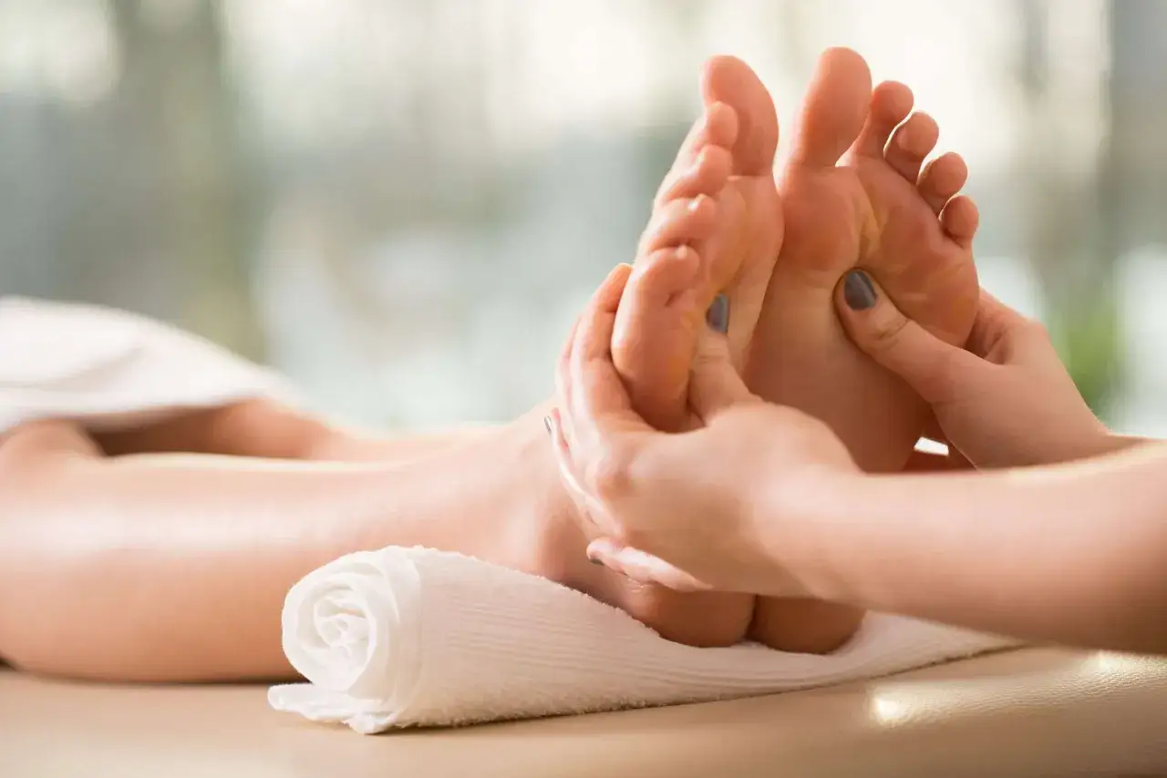 Mains massant des pieds, un remède de grand-mère contre la transpiration des pieds.