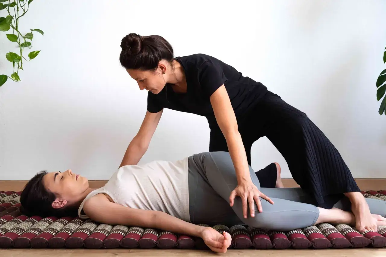 Une femme reçoit un massage thaïlandais pour bien masser son corps et relâcher les tensions.
