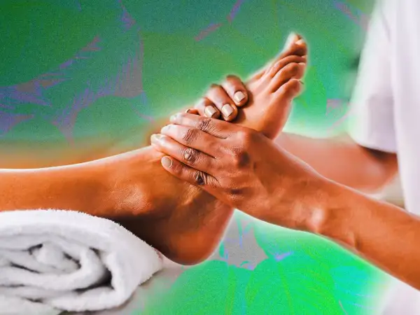 Mains massant un pied, évoquant la réflexologie plantaire colonne vertébrale pour un bien-être total.