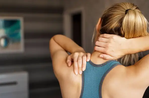 Femme se tenant le cou, souffrant d'une contracture. Que faire pour soulager cette douleur ?